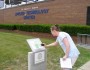 A student at St Clair County Community College scans a QR code with her smartphone to learn more about a campus green feature. Image credit St Clair County Community College.