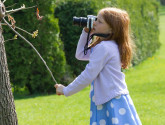 A young photographer takes pictures of an insect in a tree. Photo by National Wildlife Photo Contest entrant Anne Girton.