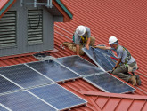 Workers installing rooftop solar panels. US National Forest Service photo by Alex Snyder.