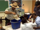 Park Rangers from Blue Heron Park assist PS 57 students with water sampling studies.