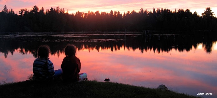 Kids watching sunset at a lake