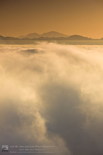 Fog fills San Francisco Bay with a silhouette of Mount Diablo in the distance - San Francisco, California