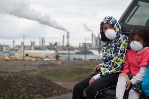 Two kids wear masks to protect them from the toxic fumes of the tar sands mining operation. Photo Credit - Healing Walk. 