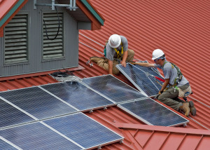 Workers installing rooftop solar panels. US National Forest Service photo by Alex Snyder. 