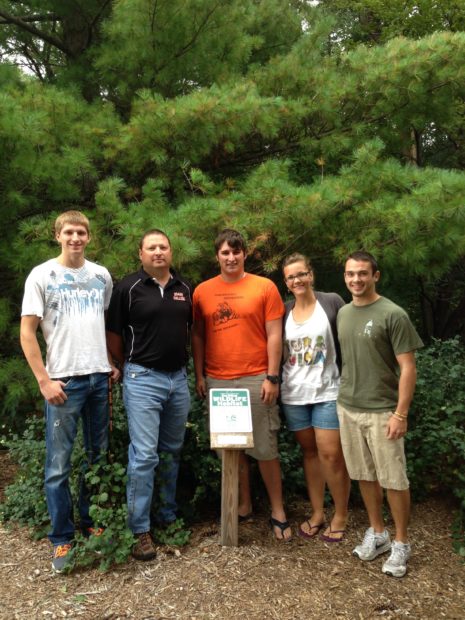 Student officers of WACO at Doane College gather with facilities director Brian Flesner at the Certified Wildlife Habitat plaque in 2013. Photo: Doane Wildlife and Conservation Organization /Sarah Genrich, photographer