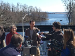NWF Senior Counsel Jim Murphy (next to Plattsburgh City Council member Rachelle Armstrong), talks to the media near rail tracks that now carry millions of gallons of dangerous oil along Lake Champlain. Photo by Ross Saxton