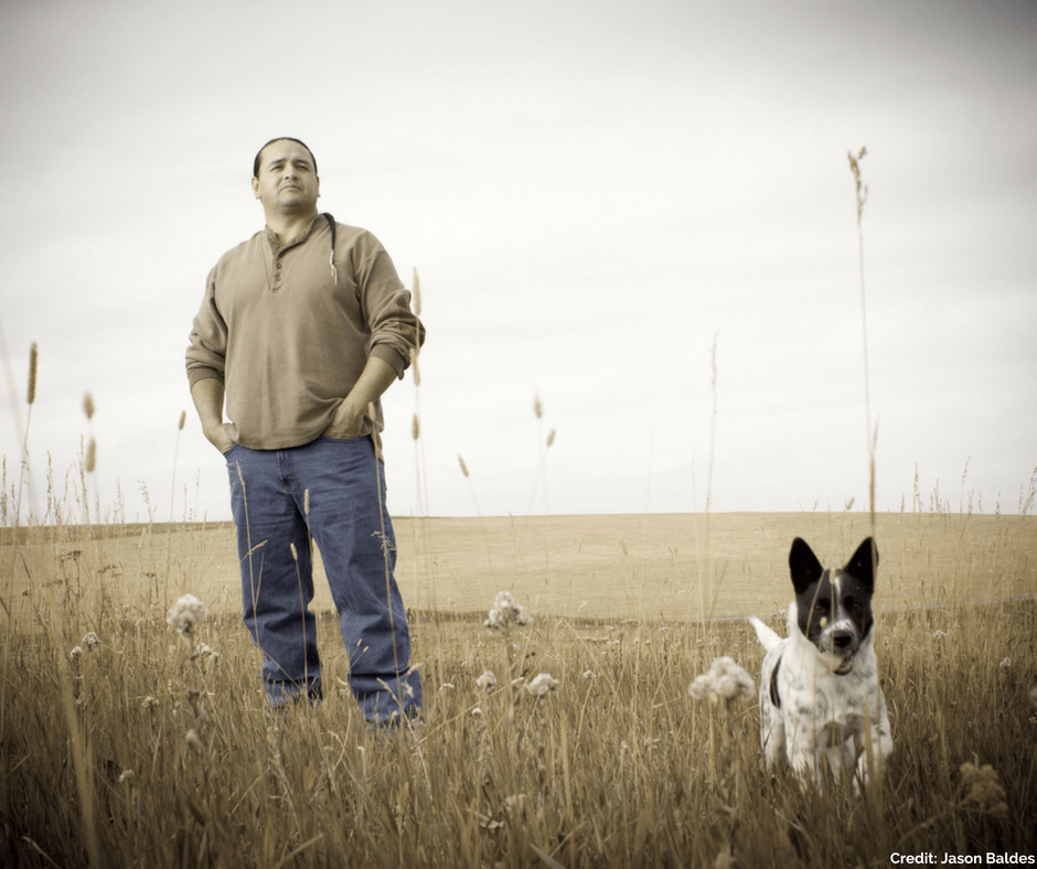 Tribal member standing on prairie landscape, once dominated by buffalo. 