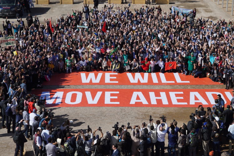 Hundreds of government and civil society supporters of the Paris Agreement pose together at the COP22 in Marrakech with a giant banner bearing the words 'We Will Move Ahead' to show their determination to move ahead with action against climate change. Photo courtesy of Greenpeace