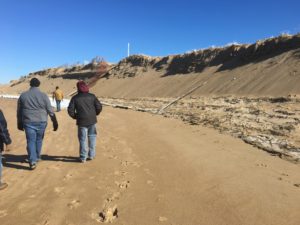 Residents walk the beach to inspect the dramatic erosion of the dune. Photo by Taj Schottland/NWF