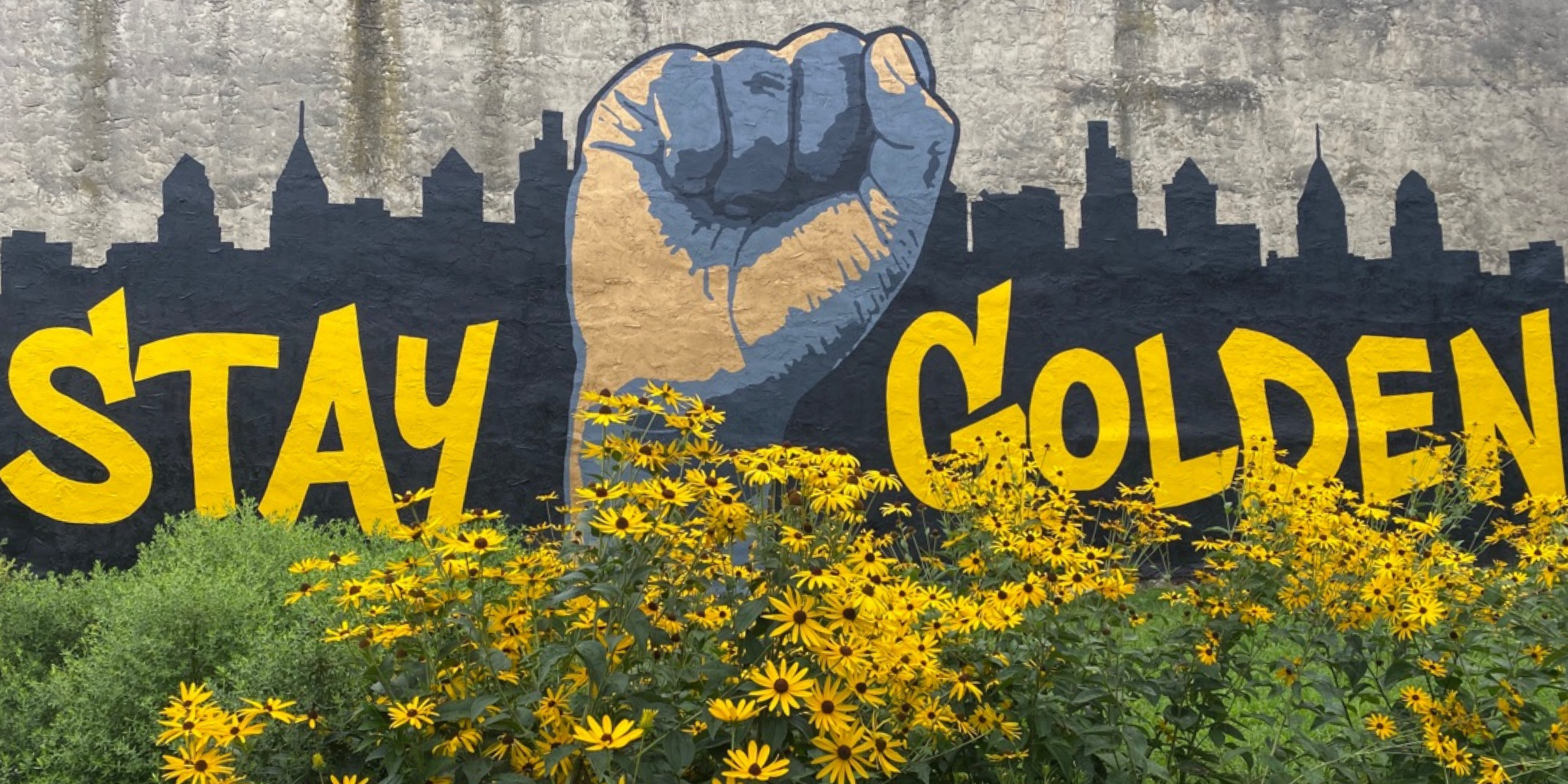 A mural that reads "stay golden" with native plants underneath.