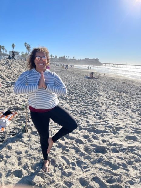 woman in yoga pose on beach