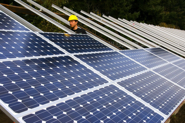 A worker installing solar panels. Photo 
