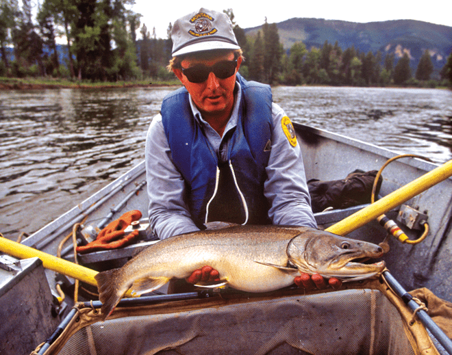 biologist holding bull trout in boat