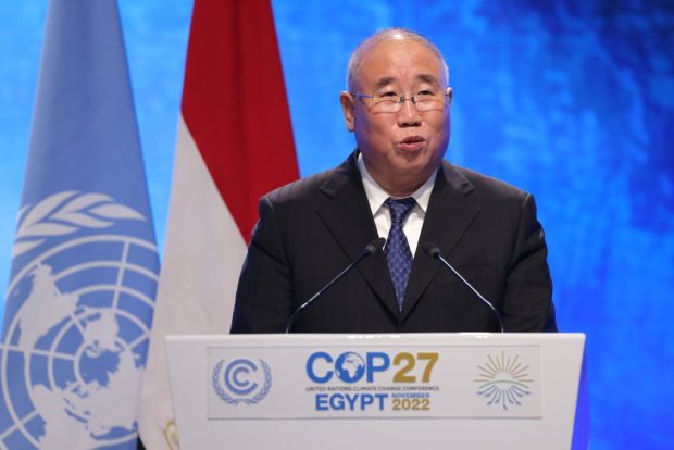 A man stands in front of a podium that reads, "COP27 Egypt 2022".