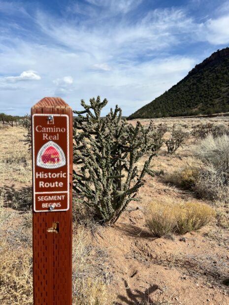 A sign on a desert hiking trail reads, "Camino Real Historic Route segment Begins".
