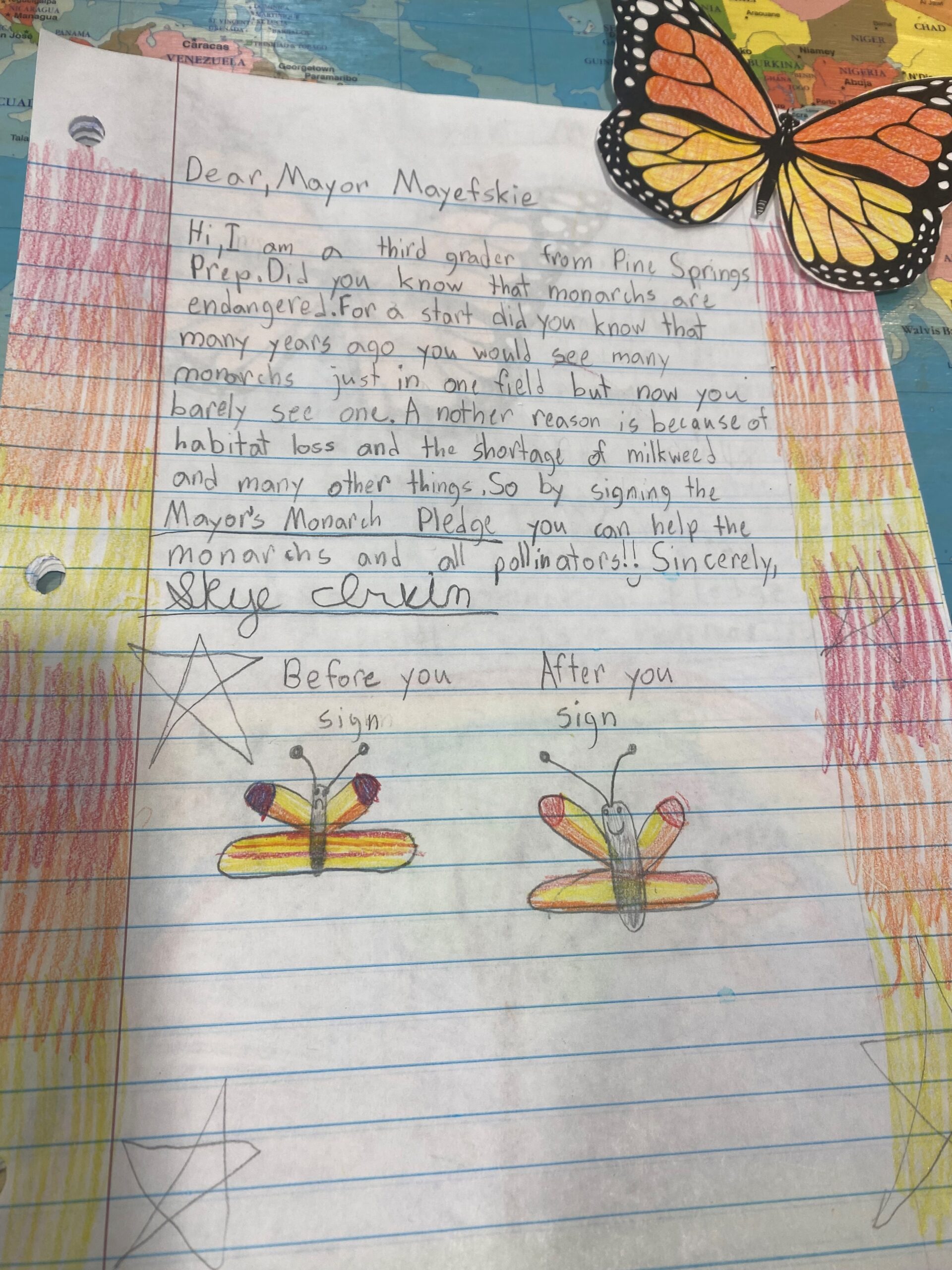 A handwritten letter featuring hand drawn pictures of butterflies on the bottom.