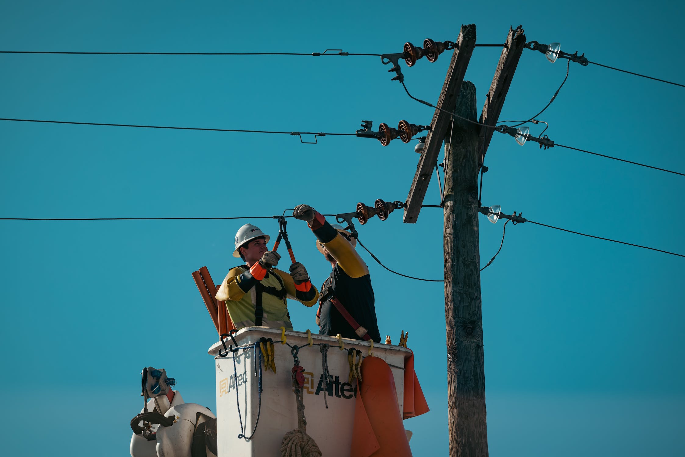 Hard hat workers attend to a power line.