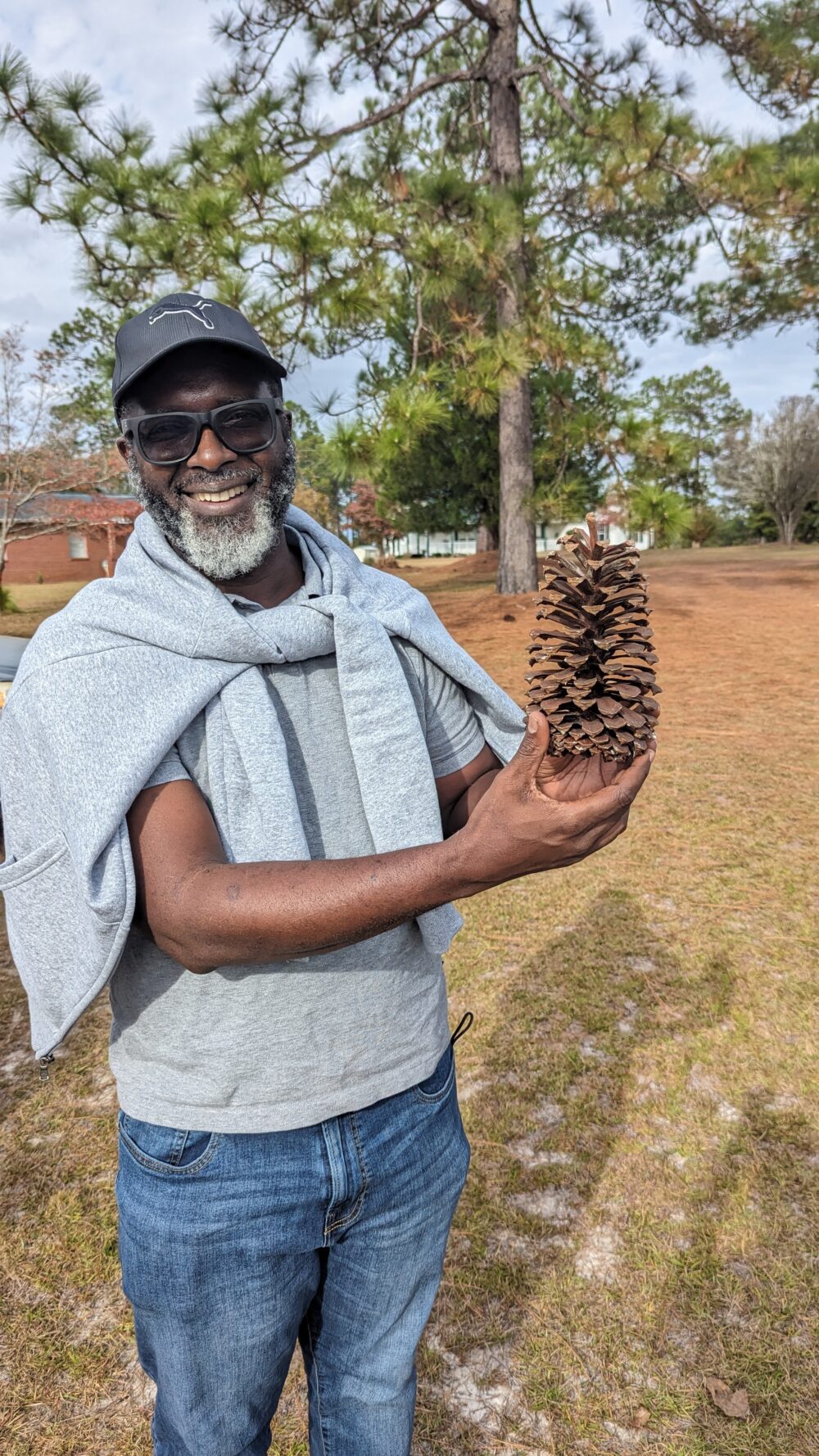 A person holds a large pine cone in their hands.
