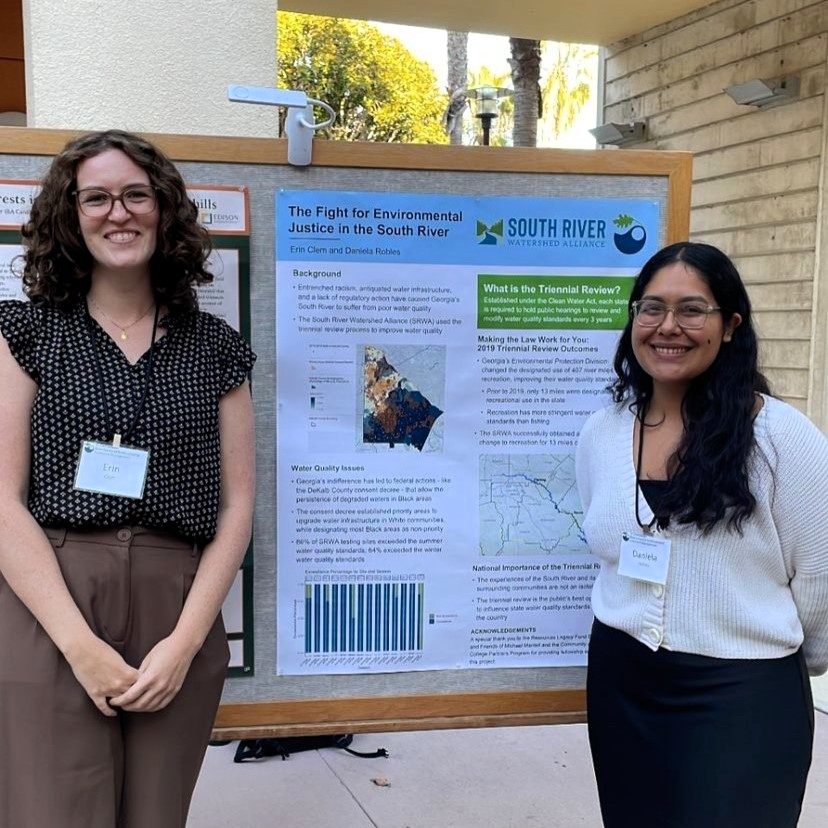 Image of UCSB students Erin Clem and Daniela Robles standing in front of a poster presentation titled The Fight for Environmental Justice in the South River.