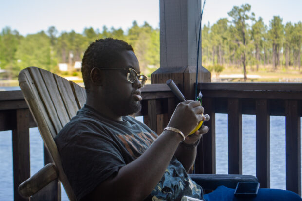 A person sitting in a chair is holding a piece of equipment.